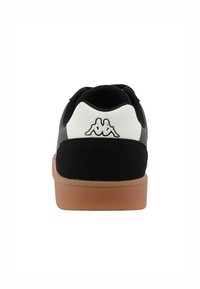 Mustvalge toss, mille ülemine osa on valmistatud kangast ja nahast, ümmargune varvas ning kummist põhjaga. Kanna peal on Kappa logo.