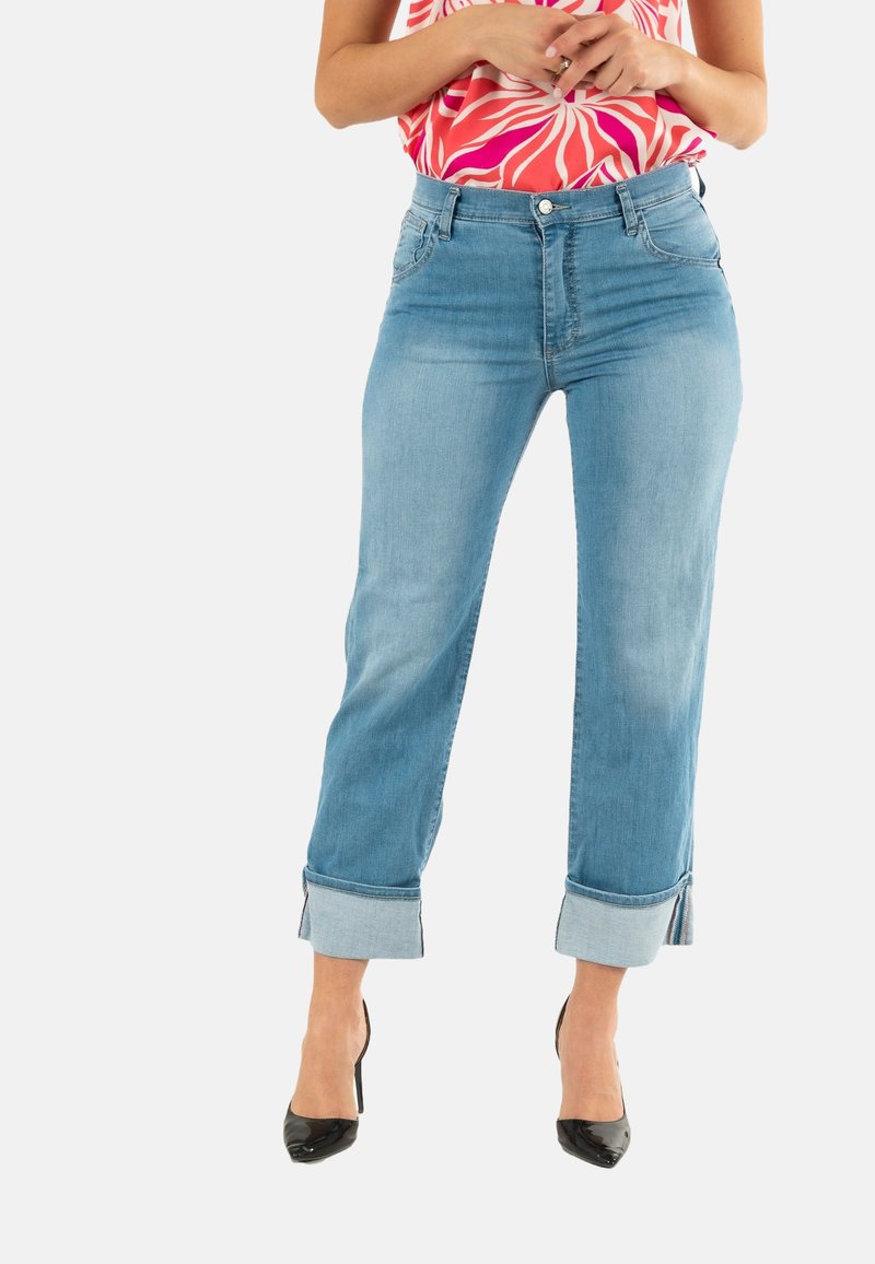 Jeans de denim azul claro con corte relajado, puños enrollados, diseño de cinco bolsillos y cierre de botón metálico en la cintura.