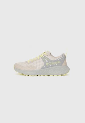 Chaussure de sport beige clair avec des accents jaunes et des détails gris. Dotée d'une tige en mesh respirant et d'une semelle en caoutchouc texturé pour une meilleure adhérence.