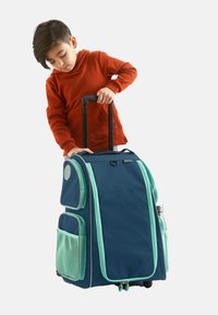 Rullande ryggsäck i marinblått tyg med mintgröna detaljer. Har ett teleskophandtag, flera fickor och slitstarka nätinslag.