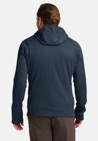 Felpa blu navy in tessuto texture, con maniche lunghe e cappuccio aderente. Presenta maniche raglan e un orlo dritto in vita.