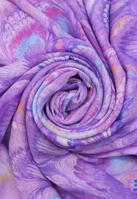 Tessuto viola con una consistenza morbida, caratterizzato da motivi astratti colorati in tonalità di blu, rosa e arancione, disposti a spirale.