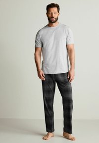 Gray short-sleeve t-shirt paired with black and gray plaid pants. The pants feature a soft texture and a relaxed fit. No visible logos.