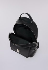Černý kožený batoh s horním uchem, otevřená hlavní přihrádka se zipem, přední kapsa se stříbrným zapínáním a nastavitelný popruh na boku.