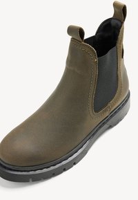 Stivale Chelsea in pelle marrone con pannello laterale elastico, pull tab e suola in gomma. Texture liscia con dettagli sottili e cuciture a contrasto.