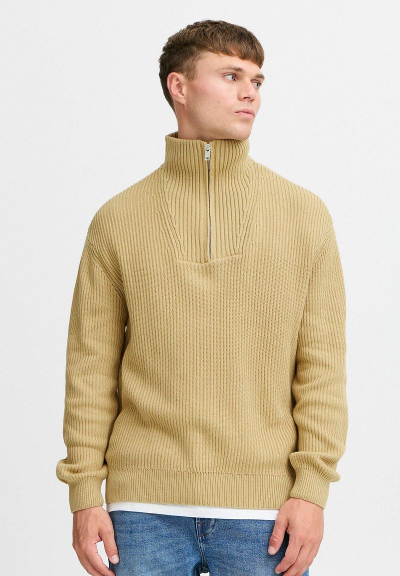 Beež ribikujuline pullover-sviiter kõrge kraega, poole tõmbega esiosa, pikad varrukad ja mugav lõige. Tekstuuriga kudum.