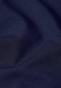 Mörkblått tyg med en mjuk textur, som har en fin väv och en lätt lyster, med subtila variationer i nyans och djup.