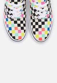 Baskets basses avec un motif à carreaux noir et blanc entrecoupé de carrés colorés, lacets blancs et semelles en caoutchouc blanches.