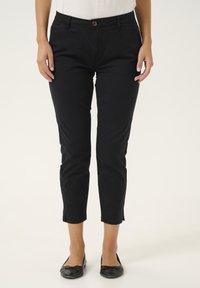 Pantaloni neri alla caviglia con un design aderente, realizzati in tessuto morbido. Presentano tasche frontali, chiusura con bottone e un orlo pulito.