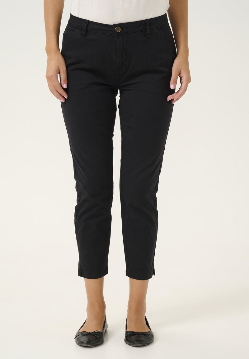 Pantaloni neri alla caviglia con un design aderente, realizzati in tessuto morbido. Presentano tasche frontali, chiusura con bottone e un orlo pulito.