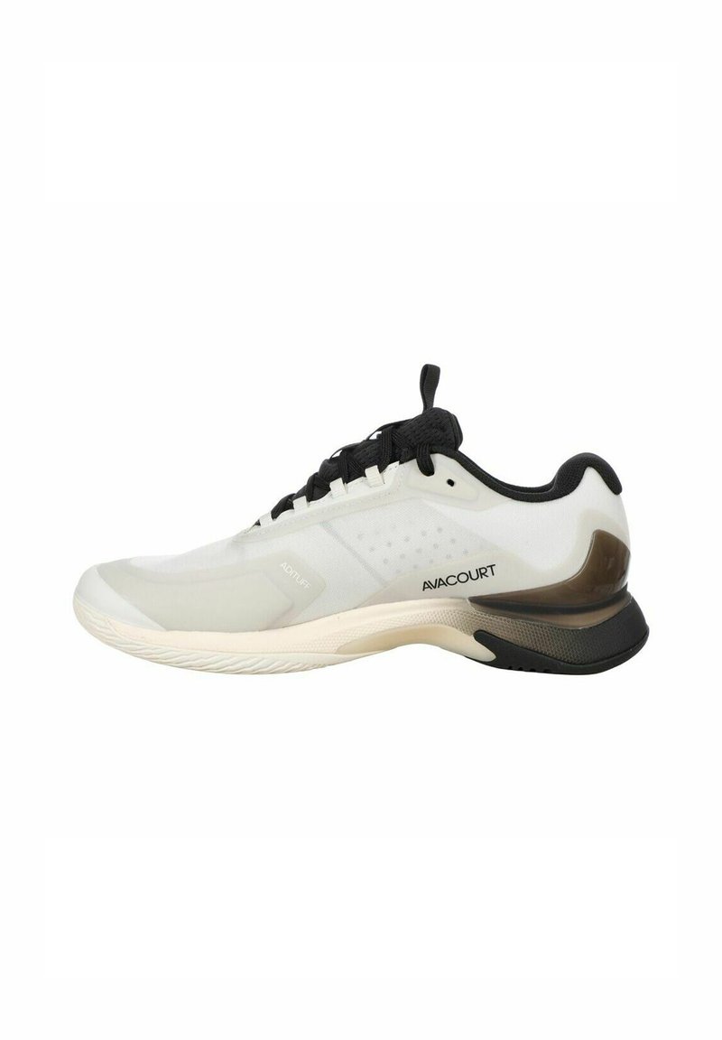 Sportlicher Schuh mit einem weißen Mesh-Obermaterial, schwarzen Akzenten und einer braunen Kunststoff-Ferseneinlage; verfügt über eine strukturierte Gummi-Sohle für besseren Halt.