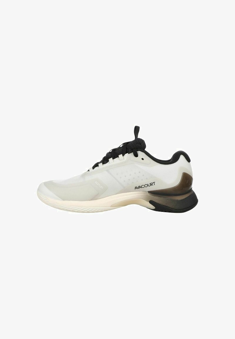 Sportlicher Schuh mit einem weißen Mesh-Obermaterial, schwarzen Akzenten und einer braunen Kunststoff-Ferseneinlage; verfügt über eine strukturierte Gummi-Sohle für besseren Halt.