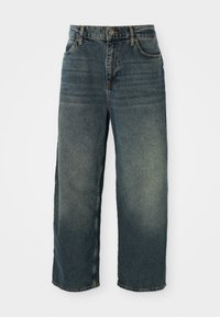 Calças de ganga de perna larga em azul claro com um acabamento desbotado. Apresentam cinco bolsos, passagens para cinto e fecho frontal com botão.