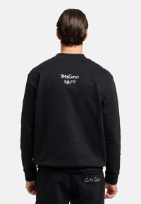 Sort sweatshirt med ribbet halsudsk�æring, prydet med "Milano 1978" broderet på ryggen. Materialet er blødt og tekstureret med en tætsiddende pasform.