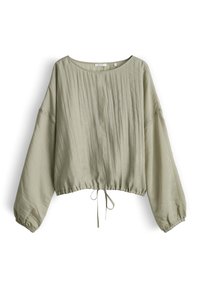 Blouse ample vert clair à manches longues, col rond, poignets froncés, plis verticaux et lien à cordon à la taille.