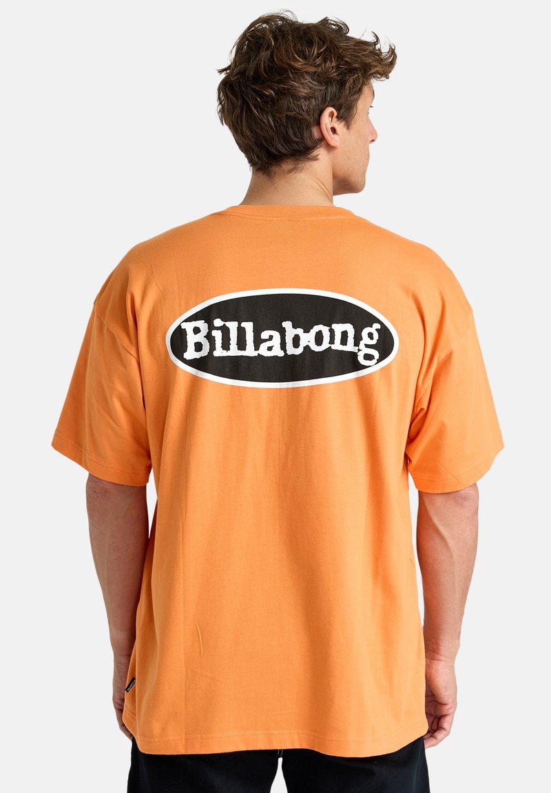 Oranžové bavlněné tričko s krátkými rukávy. Na zadní straně obsahuje černobílé kulaté logo Billabong. Rovný spodní lem a pohodlný střih.