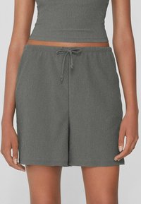 Shorts grigi leggeri con cintura elastica e cordino regolabile. Il tessuto presenta un leggero motivo testurizzato, di lunghezza circa al ginocchio.