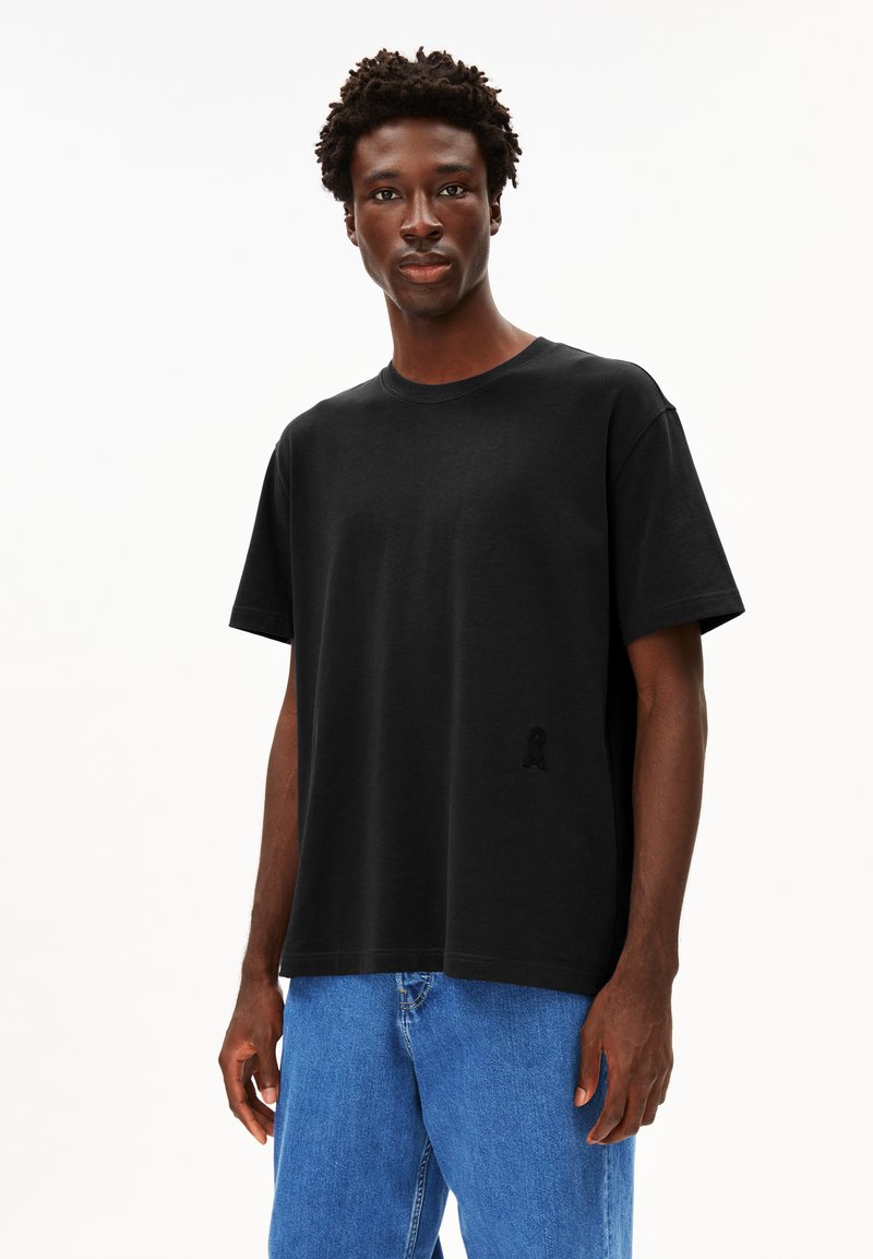Schwarzes Baumwoll-T-Shirt mit Rundhalsausschnitt und kurzen Ärmeln. Verfügt über ein dezentes gesticktes Logo im linken Brustbereich.