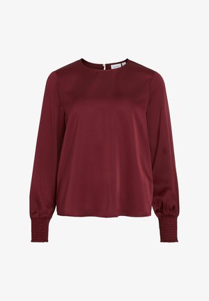 Bordeauxfarbige Bluse aus glattem Stoff, mit langen Puffärmel und gerafften Manschetten sowie einem runden Ausschnitt, mit Reißverschluss hinten.