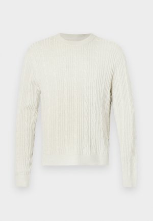 Cremfarbener Kabelstrickpullover mit rundem Halsausschnitt sowie gerippten Bündchen und Saum. Das strukturierte Design verleiht dem Stoff Tiefe.