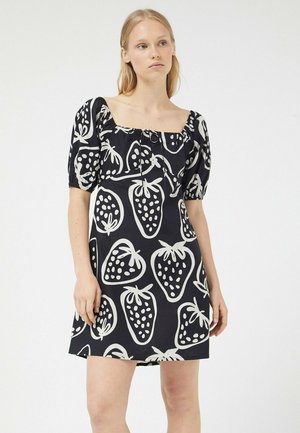 Vestido negro con grandes estampados de fresas blancas, mangas abullonadas y escote cuadrado con detalle de cordón. Textura de tela suave.