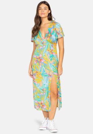 Robe maxi florale multicolore avec un décolleté plongeant, des manches courtes et une fente latérale ; assortie à des baskets montantes blanches.