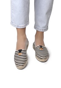 Espadrillas a righe con tomaia in tela nera e crema. Punta rotonda, inserzioni elastiche sui lati e suola avvolta in juta.