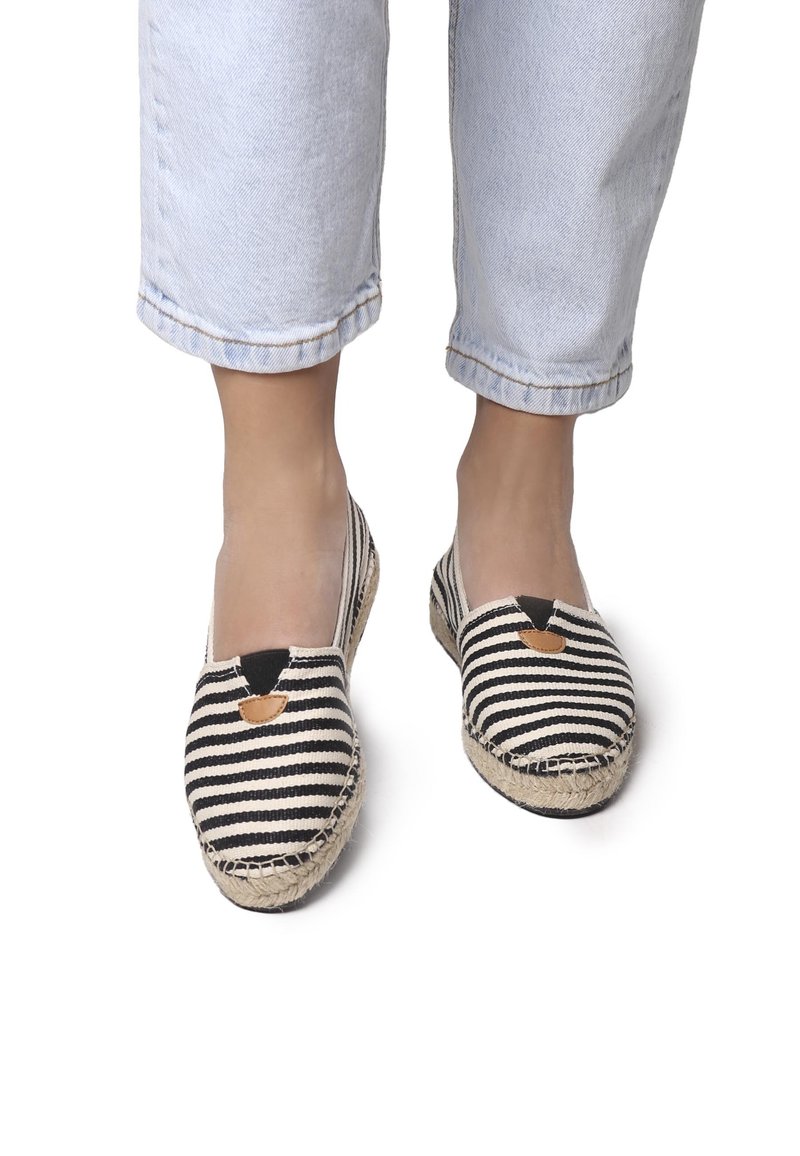 Espadrillas a righe con tomaia in tela nera e crema. Punta rotonda, inserzioni elastiche sui lati e suola avvolta in juta.