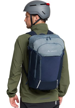 Blaue und marinefarbene Tasche mit strukturiertem Oberteil, stromlinienförmiger Form, verstellbaren Riemen und reflektierenden Akzenten, entworfen für den Einsatz im Freien.