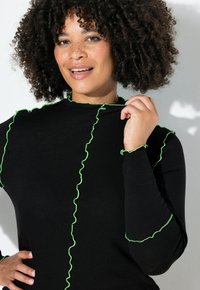 Zwart top met lange mouwen, voorzien van gerimpelde neon groene rand langs de halslijn en mouwen, gemaakt van een gladde, lichte stof.