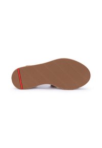 Sole in gomma con una finitura marrone testurizzata, caratterizzata da scanalature orizzontali e diagonali, e una striscia di accento rossa vicino al tallone.
