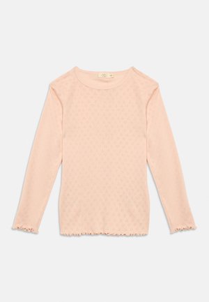 Heleroosa pikkade varrukatega kootud topp peene teemantmustriga, ümar kaelus ja volangidega äärtega mansettidel ja serval.