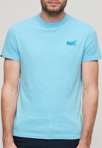 T-shirt azzurro chiaro a maniche corte realizzato in tessuto morbido, con un piccolo logo ricamato sul lato sinistro del petto. Collo a giro, vestibilità comoda.