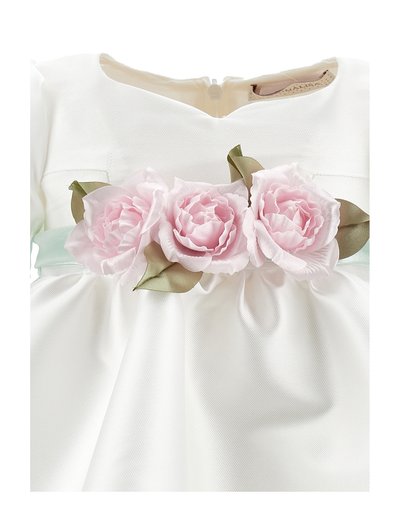 Weißes, strukturiertes Stoffkleid mit drei rosa Stoffrosen und grünen Blättern, die an der Taille an einem hellblauen Gürtel befestigt sind.