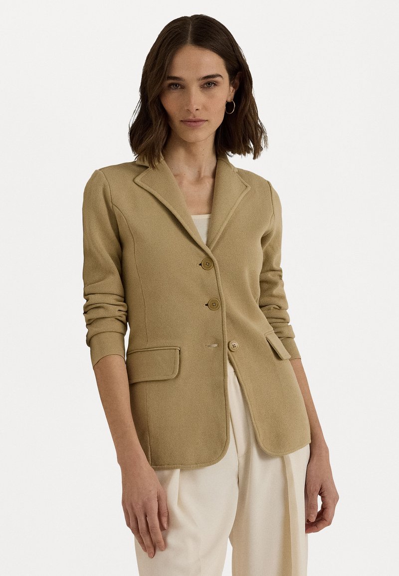 Lys beige blazer med en strukturert design, enkelspent front, tre knapper og to lommer; teksturert stoff med en glatt overflate.