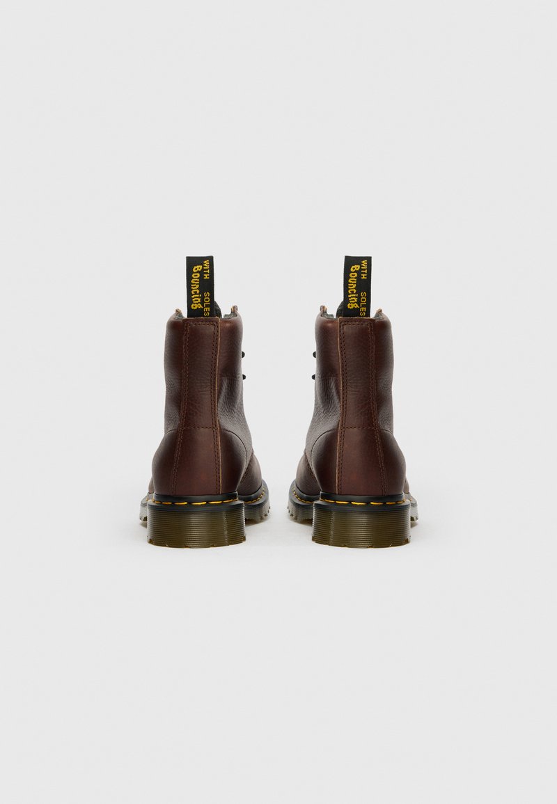 Braune Leder-Stiefeletten mit strukturiertem Finish, ausgestattet mit gelben und schwarzen Zuglaschen sowie einer gelb genähten Sohle.