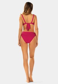 Magenta bikini z halterem i zawiązywaniem oraz standardowym dołem. Gładka tekstura, minimalistyczny design.
