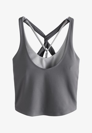 Grå sports-bh med dobbelt krydset stropper og en rund udskæring, designet til atletisk eller afslappet brug, vist mod en hvid baggrund.