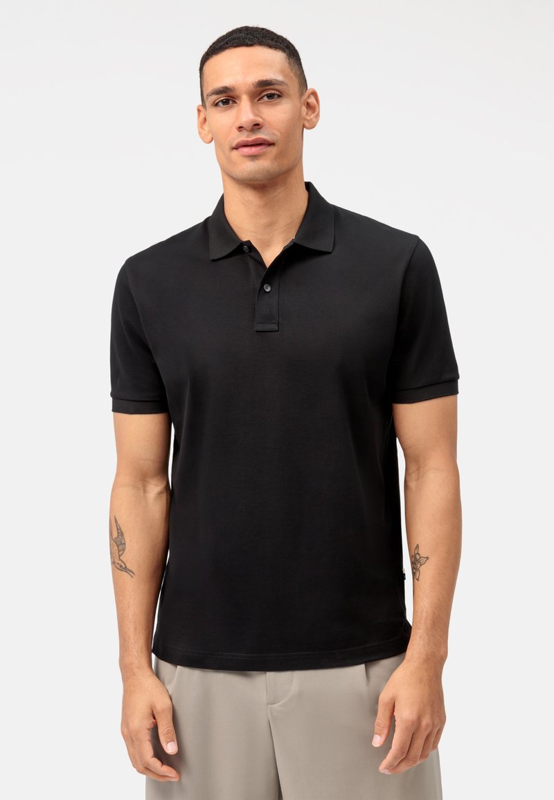 Polo nero in cotone con colletto classico, maniche corte e patta con tre bottoni. Texture liscia e design aderente.