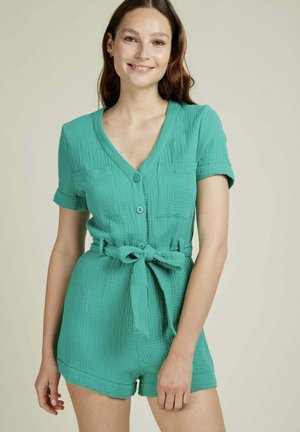 Combinaison en coton turquoise avec des manches courtes, décolleté en V, fermeture à bouton sur le devant, deux poches poitrine et une taille ceinturée. Tissu texturé avec une coupe décontractée.
