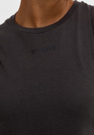 Musta urheilullinen toppi, valmistettu hengittävästä kankaasta, jossa on teksturoitu pinta. Siinä on pyöreä kaula-aukko ja kohokuvioitu logo rinnassa.