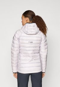 Világos lila, szigetelt pufi dzseki kapucnival, steppelt mintázattal, elasztikus mandzsettákkal és diszkrét logóval a hátsó részen.