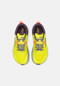 Zapatillas de trail running amarillas con parte superior de malla transpirable, acentos morados, suelas grises y cordones y detalles reflectantes.