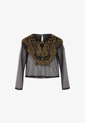 Musta verkkopaita lyhyellä helmaosalla, jossa on pitkät hihat, kultaisella helmikoristeisella perhosikuvioinnilla sekä teksturoiduilla yksityiskohdilla kaula-aukon ja helman ympärillä.