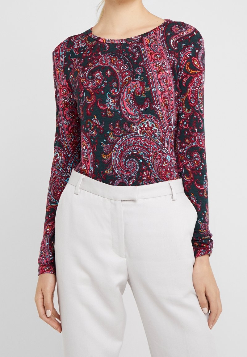 Long-sleeve top with a dark background featuring a colorful paisley pattern in shades of pink, red, and blue; soft fabric and fitted design.
