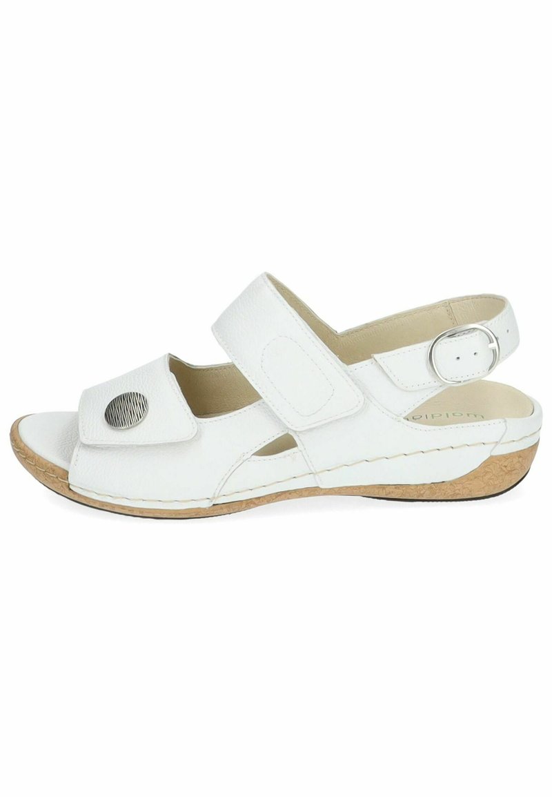 Sandale en cuir blanc avec des sangles ajustables, un accent métallique circulaire et une semelle en liège. Bout ouvert et découpes latérales pour une meilleure circulation de l'air.