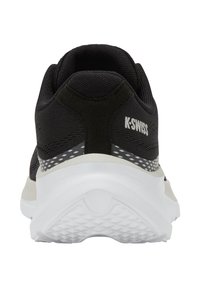 Zadní pohled na černou tenisku K-Swiss s bílou podrážkou a texturovaným gripem, zobrazující logo značky na bočním patě.