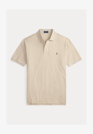 Bež polo majica s kratkimi rokavi, ovratnikom in ploščico z dvema gumboma, z majhnim izvezenim logotipom konja na levi strani prsnega koša.