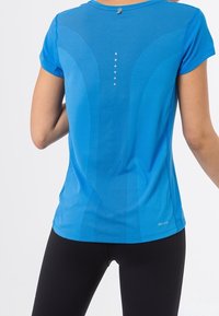 Modré sportovní tričko s krátkými rukávy, texturovanou látkou, zakřiveným švem a reflexními prvky na zádech pro lepší viditelnost.