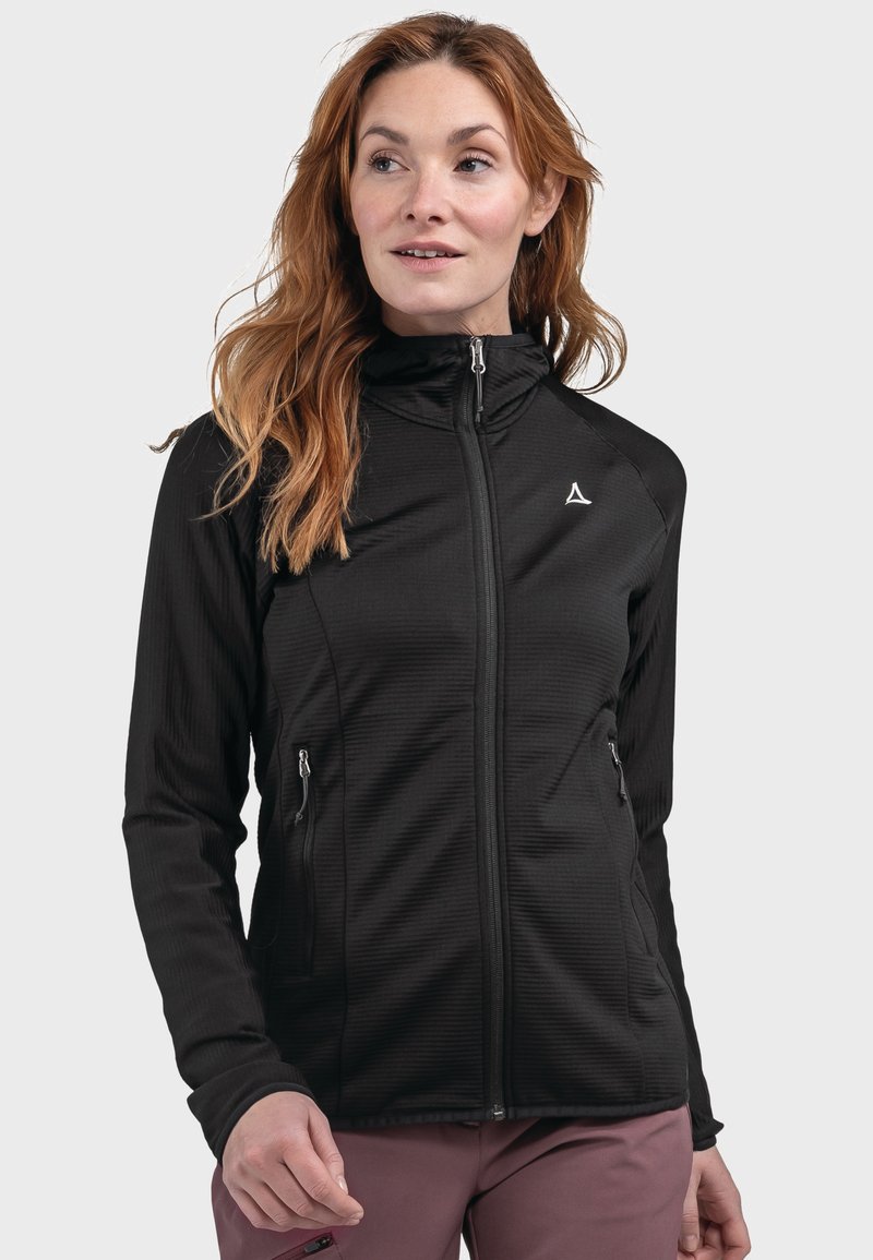 Giacca nera con zip e colletto alto, tessuto strutturato, due tasche laterali e un piccolo logo sul petto. Presenta un design aderente.
